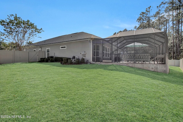 back of property with a lanai and a lawn