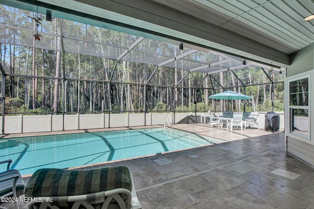 view of swimming pool with a patio and a lanai