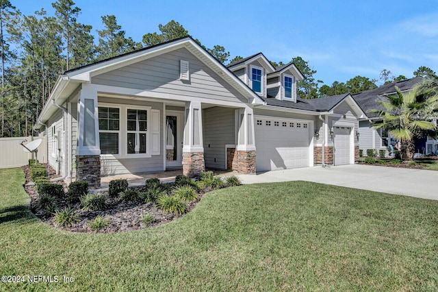 craftsman-style home featuring covered porch, a garage, and a front yard