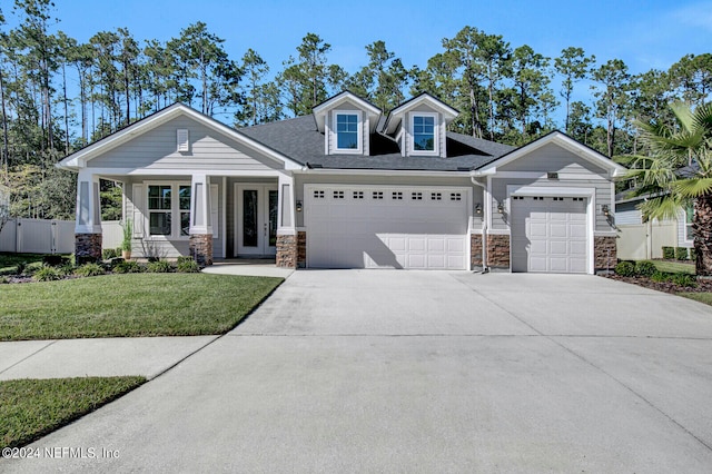 view of front of home with a front yard, a porch, and a garage