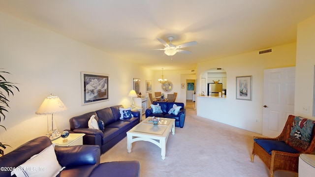 living room featuring arched walkways, ceiling fan with notable chandelier, and light colored carpet