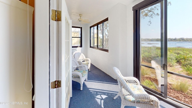 sunroom featuring a water view