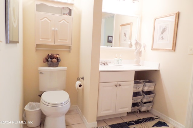 half bath with tile patterned floors, baseboards, toilet, and vanity