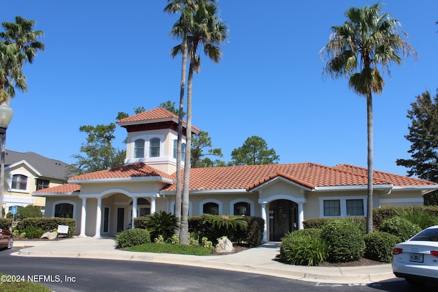 mediterranean / spanish home featuring stucco siding and a tiled roof