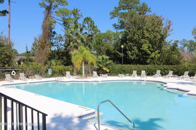 pool with a patio and fence