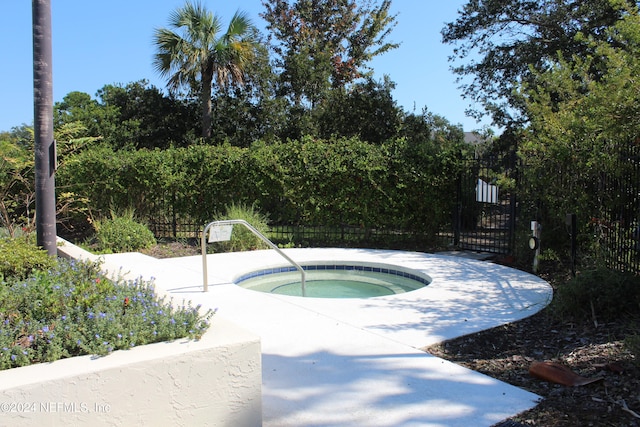 view of swimming pool with an in ground hot tub, a gate, and fence