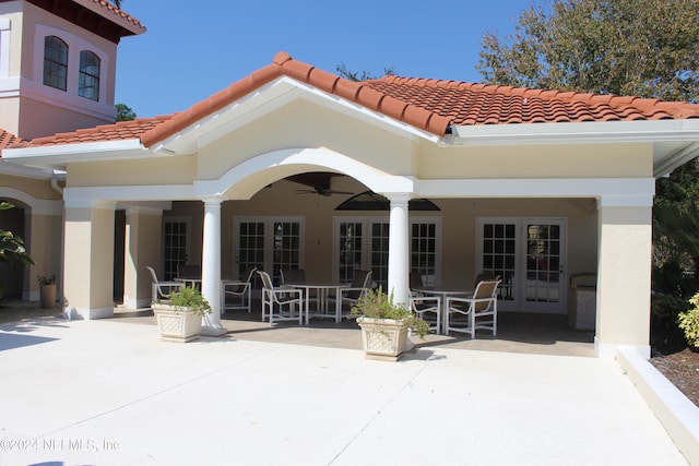 rear view of property with french doors, a tile roof, ceiling fan, and a patio area