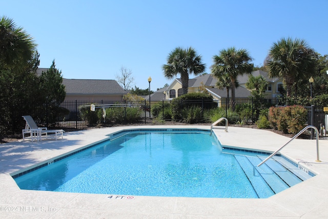 community pool featuring a patio and fence