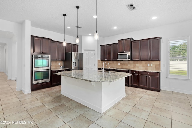 1309 Acorn Ridge Ct, Saint Augustine, FL 32092 - kitchen featuring a textured ceiling, light tile patterned floors, backsplash, and stainless steel appliances