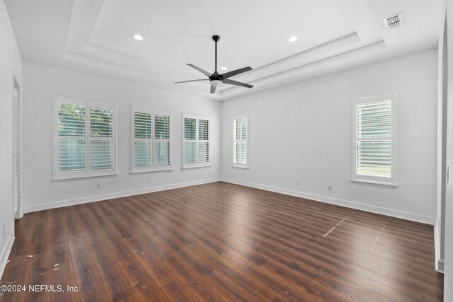 1309 Acorn Ridge Ct, Saint Augustine, FL 32092 - empty room with a ceiling fan, a tray ceiling, dark wood finished floors, and plenty of natural light