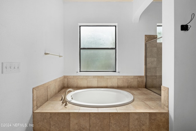 bathroom with tiled bath and a wealth of natural light