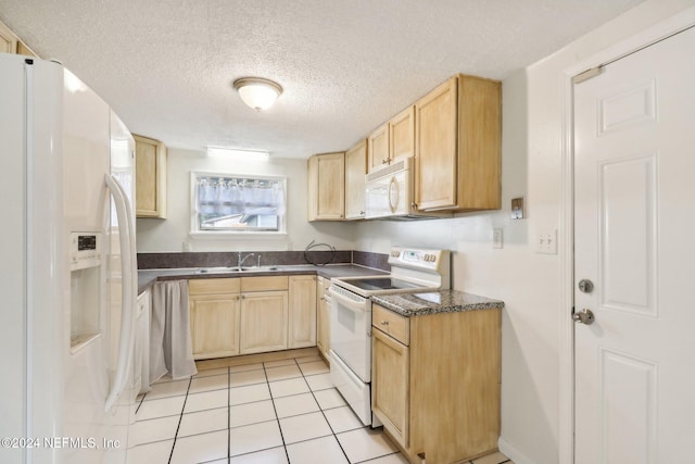 kitchen with a textured ceiling, sink, light tile patterned floors, light brown cabinetry, and white appliances