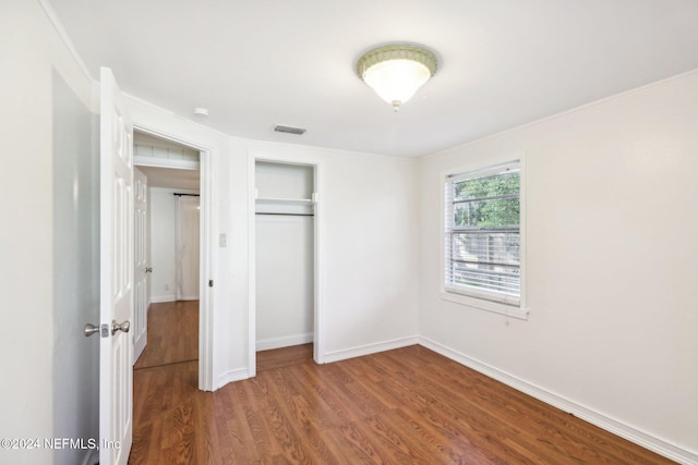 unfurnished bedroom featuring wood-type flooring and a closet