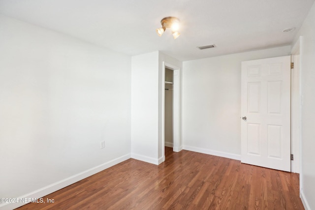 unfurnished bedroom with hardwood / wood-style flooring and a closet