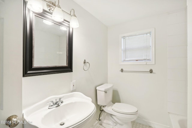 bathroom featuring tile patterned flooring, a washtub, toilet, and sink