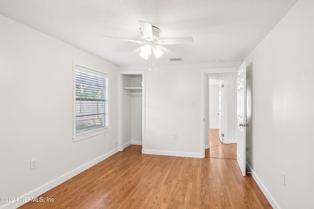 unfurnished bedroom with light hardwood / wood-style floors, ceiling fan, and a closet