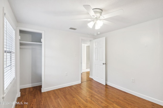 unfurnished bedroom with a closet, hardwood / wood-style floors, and ceiling fan