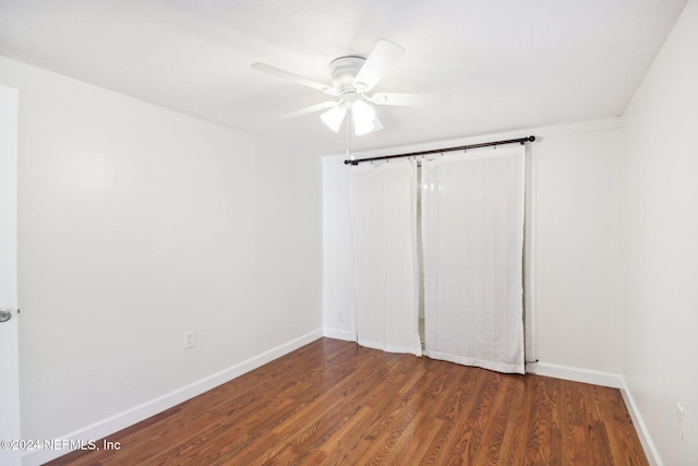 spare room with dark wood-type flooring and ceiling fan