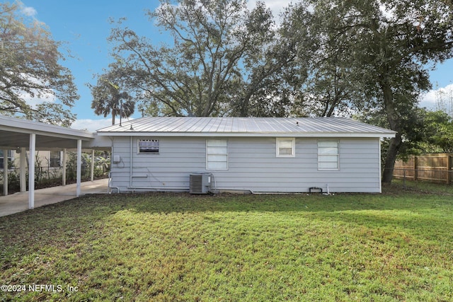 back of property with central air condition unit, a lawn, and a patio area