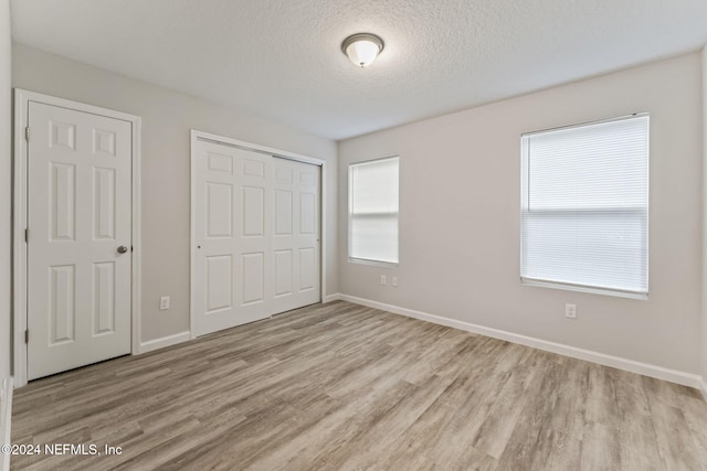 unfurnished bedroom featuring a textured ceiling and light wood-type flooring