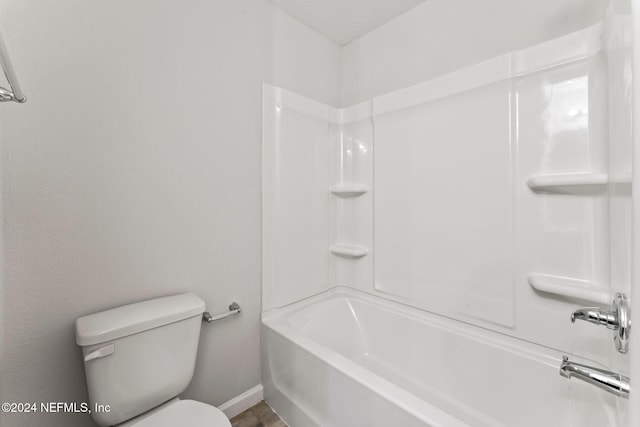 bathroom featuring  shower combination, a textured ceiling, and toilet