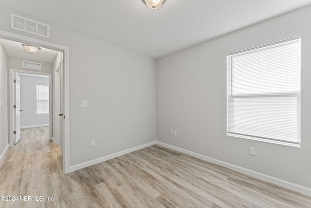 unfurnished room featuring light hardwood / wood-style floors and plenty of natural light