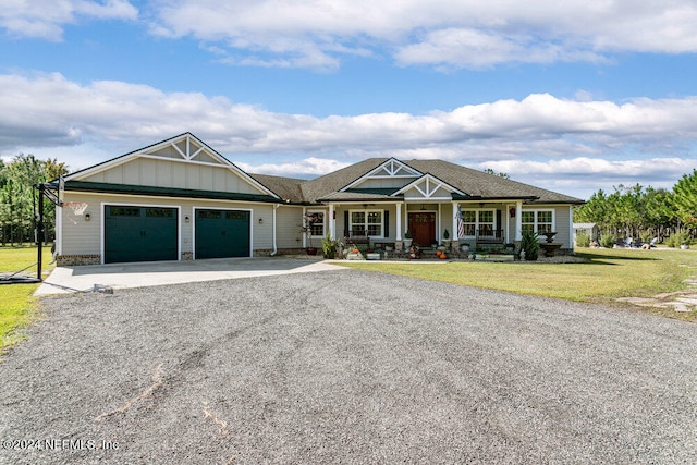 view of front facade featuring a front yard, a garage, and a porch