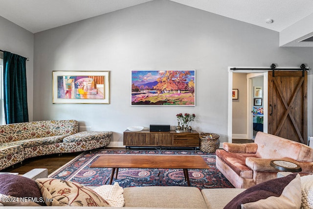 living room with a barn door, hardwood / wood-style flooring, and vaulted ceiling