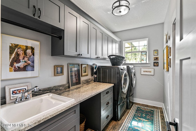 clothes washing area with sink, separate washer and dryer, a textured ceiling, cabinets, and dark hardwood / wood-style floors