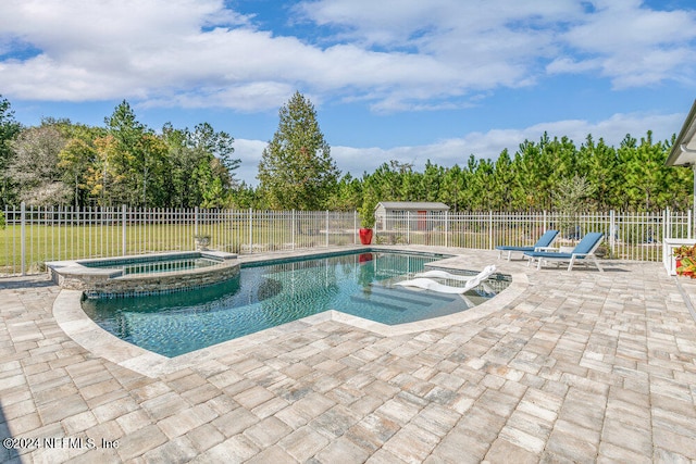 view of pool with a patio area and an in ground hot tub