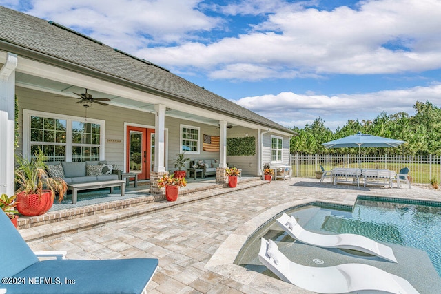 view of swimming pool with ceiling fan, a patio area, and an outdoor living space