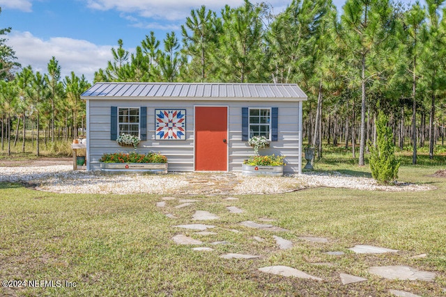 view of front of property featuring a front yard and an outbuilding