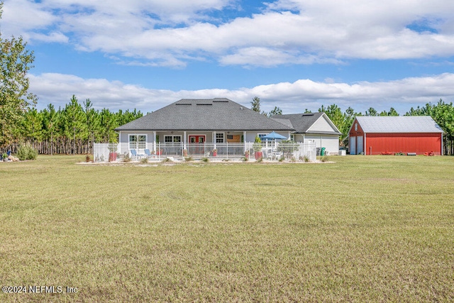 back of property featuring an outdoor structure and a lawn