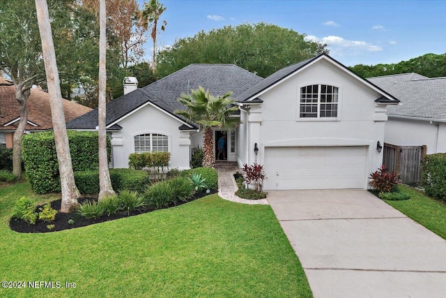 ranch-style home with a garage and a front lawn