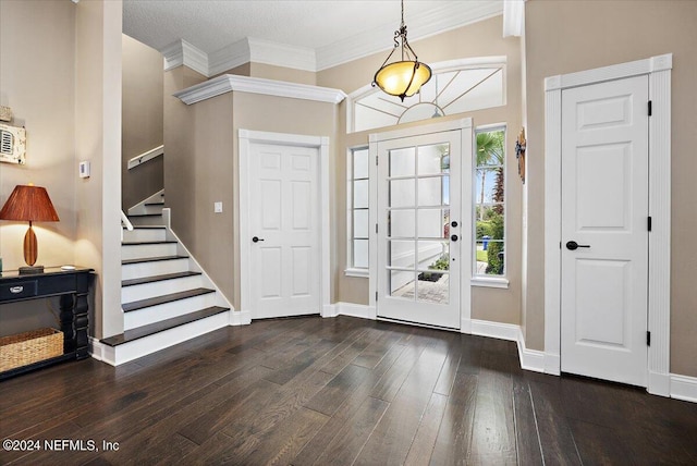 foyer entrance featuring ornamental molding, a textured ceiling, and dark wood-type flooring