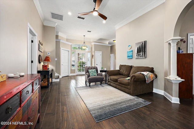 living room featuring ornate columns, ornamental molding, dark hardwood / wood-style flooring, a textured ceiling, and ceiling fan