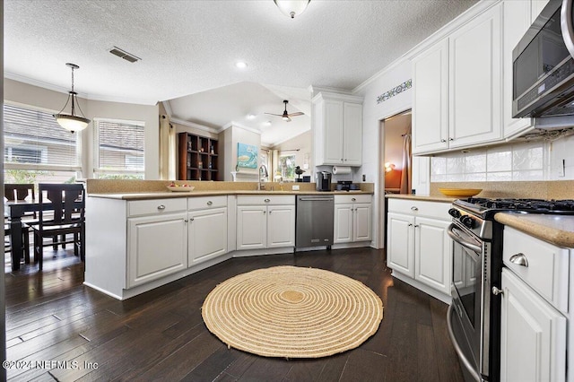 kitchen featuring a textured ceiling, kitchen peninsula, white cabinetry, stainless steel appliances, and dark hardwood / wood-style floors