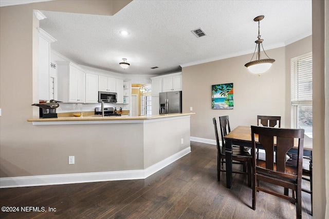 kitchen with appliances with stainless steel finishes, kitchen peninsula, dark hardwood / wood-style floors, and white cabinets