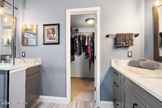 bathroom featuring vanity, hardwood / wood-style floors, and a textured ceiling