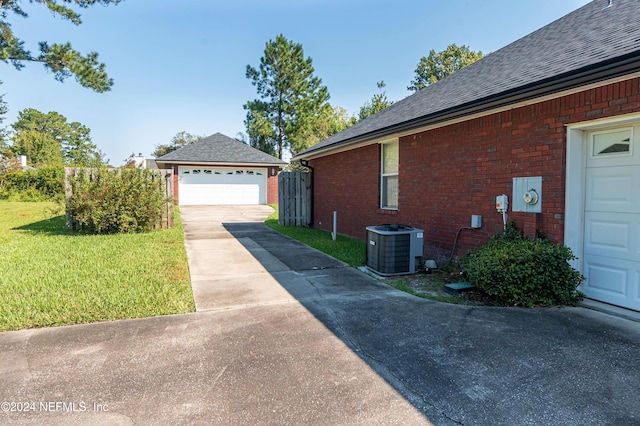 view of home's exterior featuring a yard, central AC, and a garage