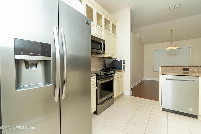 kitchen featuring tasteful backsplash, light tile patterned floors, an inviting chandelier, stainless steel appliances, and decorative light fixtures