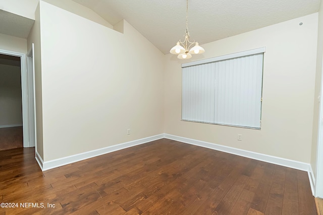 unfurnished room featuring a notable chandelier, a textured ceiling, vaulted ceiling, and dark hardwood / wood-style flooring