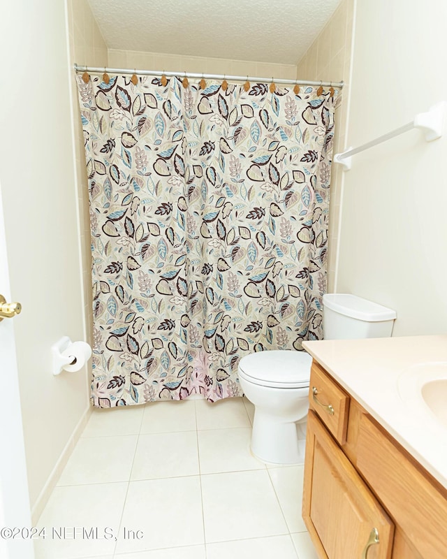 bathroom with vanity, a textured ceiling, toilet, and tile patterned floors