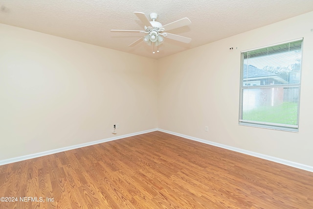 spare room with ceiling fan, wood-type flooring, and a textured ceiling