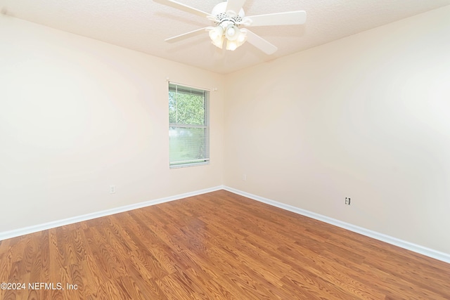 spare room with hardwood / wood-style floors, a textured ceiling, and ceiling fan