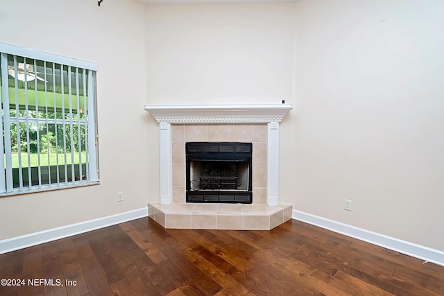 unfurnished living room with hardwood / wood-style floors and a tile fireplace