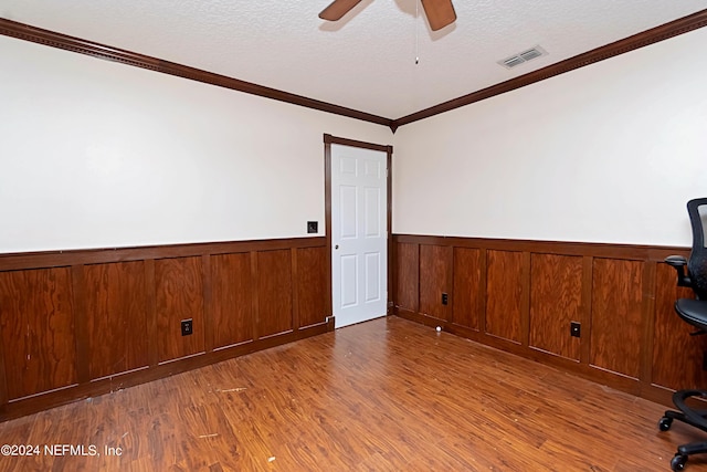 spare room featuring hardwood / wood-style floors, crown molding, and a textured ceiling