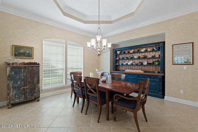 dining space featuring ornamental molding, a chandelier, a raised ceiling, and light tile patterned floors