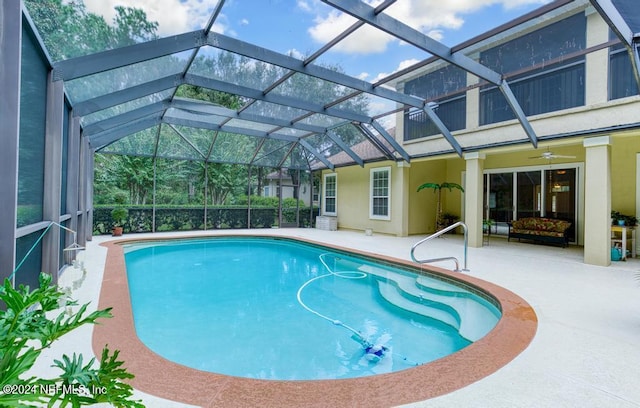 view of pool featuring ceiling fan, a lanai, and a patio area