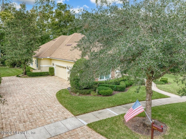 view of front of property featuring a garage and a front lawn